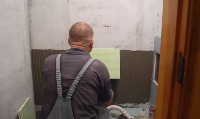 Совместите центр плитки с вертикальной осью симметрии стены