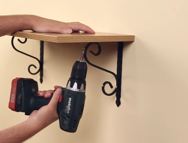 Доску фиксируют коротким саморезом через отверстие в кронштейне