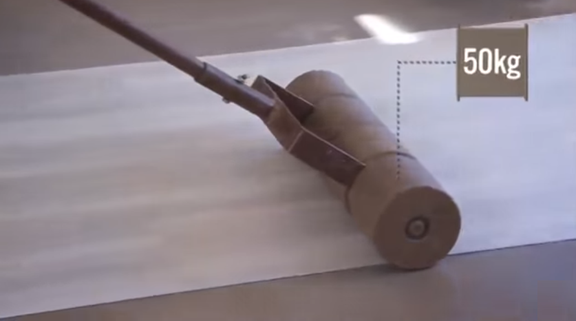 Использование прикаточного валика для лучшего приклеивания ПВХ плитки