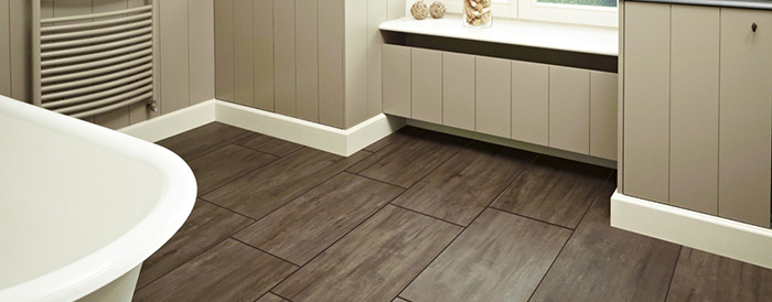 На фото ПВХ плитка на полу в ванной комнате, рисунок - имитация дерева