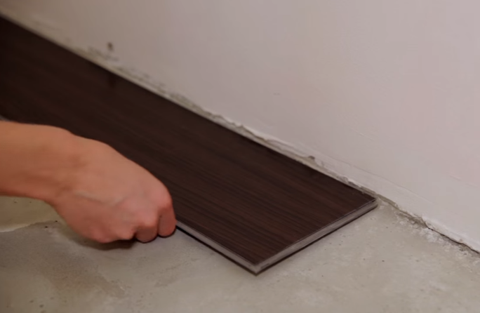 Начинайте монтаж с угла комнаты. Уложите плитку так, чтобы выступ замков смотрел на вас