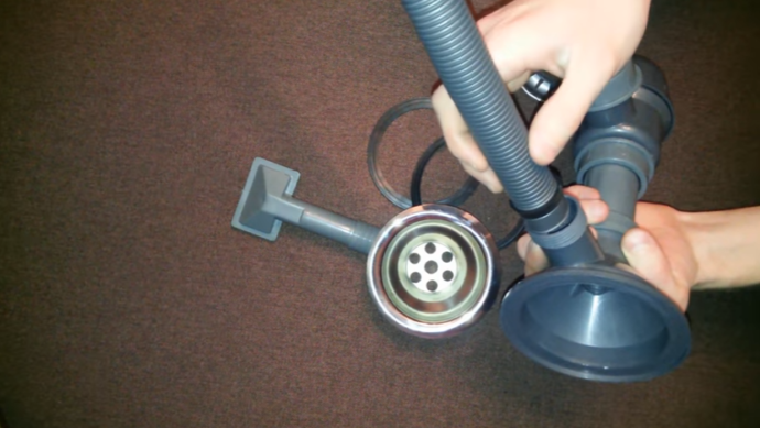 Надеваем уплотнитель на гофрированный шланг, вставляем конец шланга в отверстие сифона