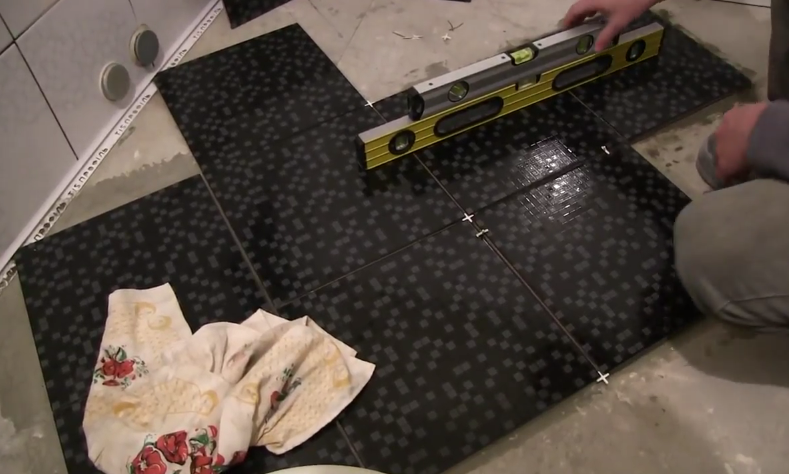 Процесс укладки плитки на пол