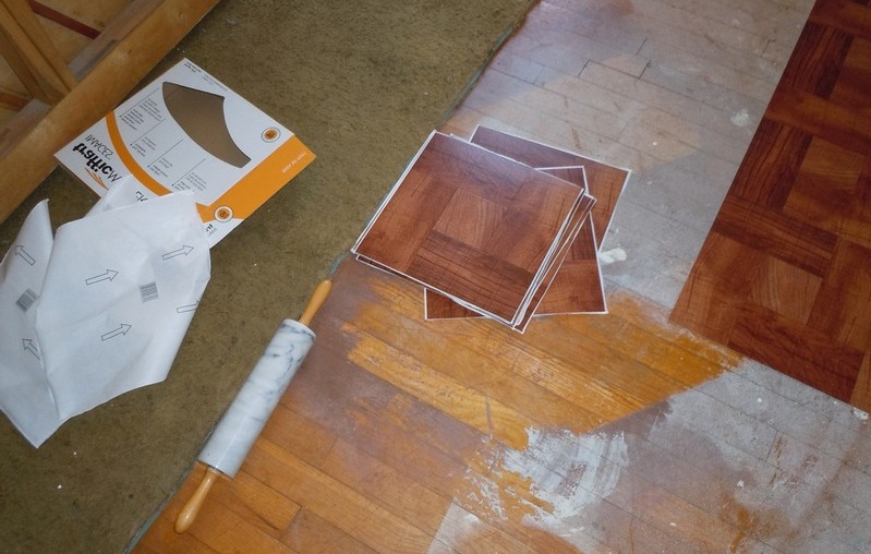 Самоклеящаяся плитка укладывается в два счета. Достаточно снять защитную пленку с изнаночной стороны и прижать плитку к полу