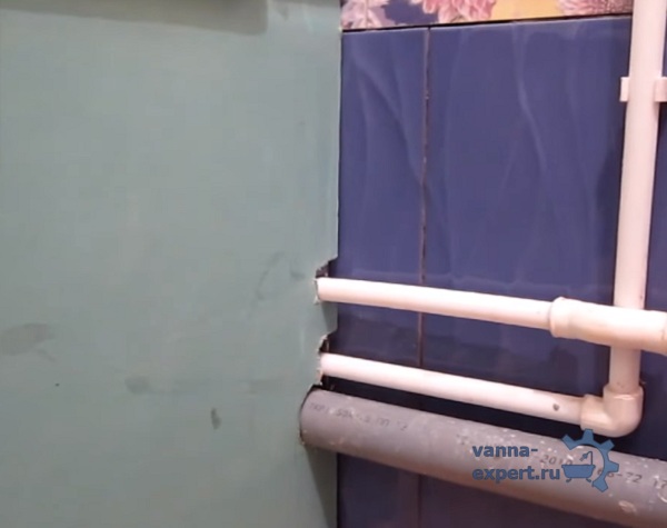 В листе гипсокартона вырезаны отверстия под трубы