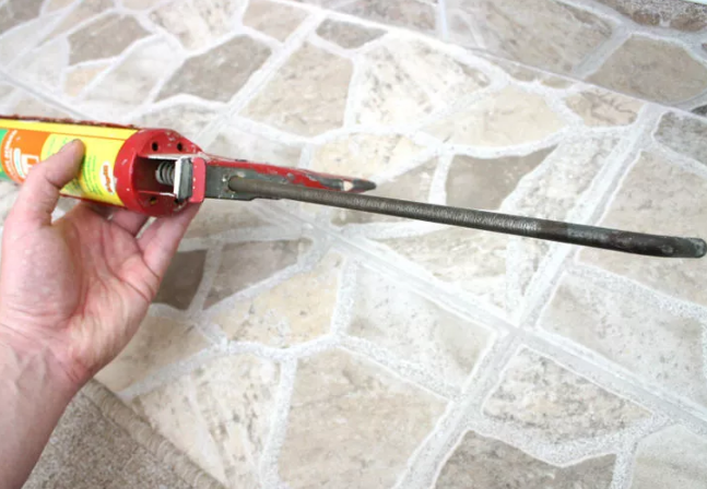 Нажмите на прижимную рейку в задней части пистолета и прижмите ее к донышку тубы, чтобы малейшее нажатие выдавливало герметик